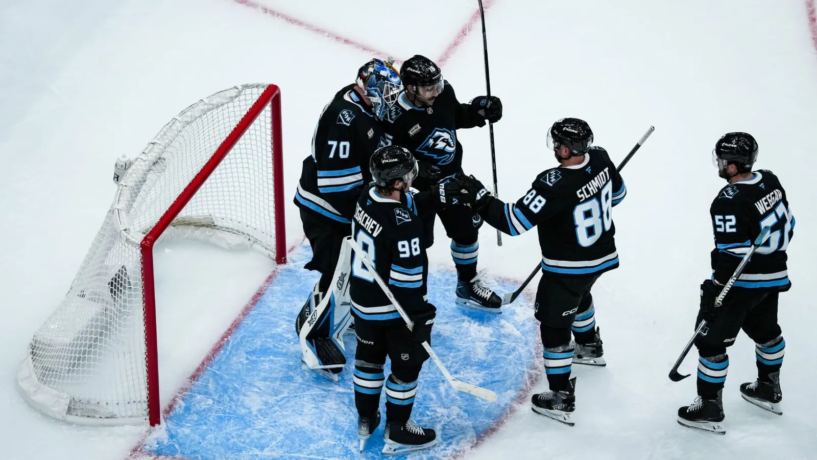 Utah goaltender Karel Vejmelka (70) is surrounded by teammates including Mikhail Sergachev (98), Nate Schmidt (88) and MacKenzie Weegar (52) in front of the Mammoth net
